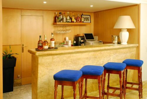 塞维利亚天主教国王酒店的厨房里设有蓝色软垫凳子的酒吧