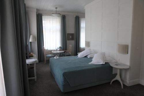 卡尔斯喀尔酒店的一间卧室配有一张蓝色的床和一张桌子