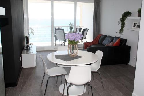 莫莱拉Penthouse Seaside的客厅配有白色的桌子和椅子