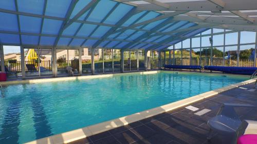 波尔特拜VVF Cotentin Îles anglo-normandes的一座拥有蓝色天花板的大型游泳池