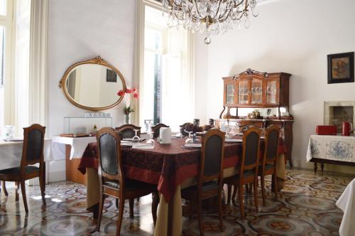 莱切罗洛宫酒店的一间带桌椅和镜子的用餐室