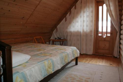 斯科列Cottage Smerekovyi的一间卧室设有一张床和木制天花板