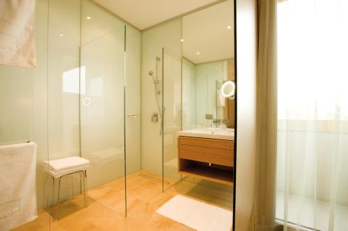 哈德时见酒店的一间带玻璃淋浴和水槽的浴室