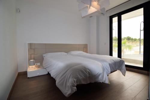 卡拉德米哈斯Dream Gardens的白色的卧室设有一张大床和一个窗户
