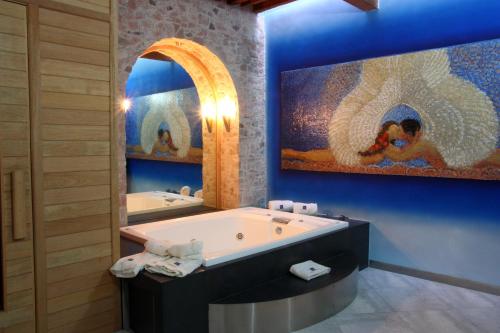 克雷塔罗Casona de la Republica Hotel Boutique & SPA的一间带大浴缸和大画的浴室