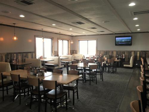 LakotaSunlac Inn Lakota的餐厅设有桌椅和平面电视。