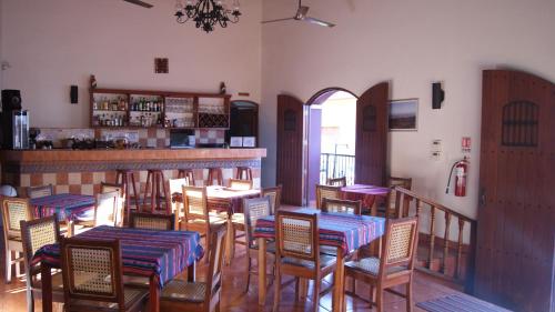 莱昂Hotel Cacique Adiact的一间带桌椅的餐厅和一间酒吧