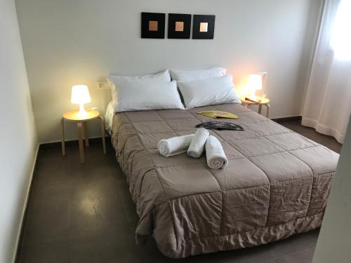 德尼亚Apartamentos Fercamar Denia的一间卧室配有一张大床和毛巾