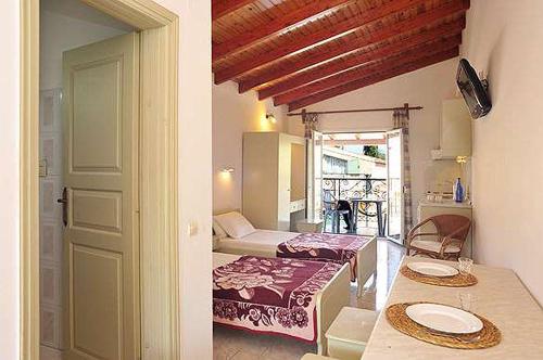 卡西奥皮Philippos Kassiopi Apartments的一间设有一张桌子和一张床的房间