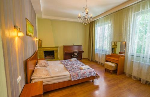第比利斯银色酒店的一间卧室配有一张床、一张桌子和一个壁炉