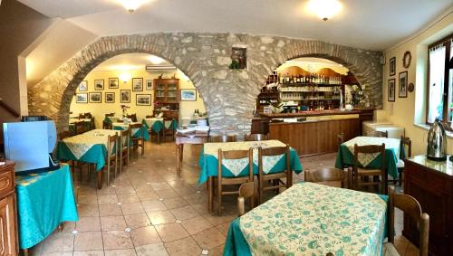 托里德尔贝纳科Locanda Speranza的一间带桌椅和石墙的餐厅