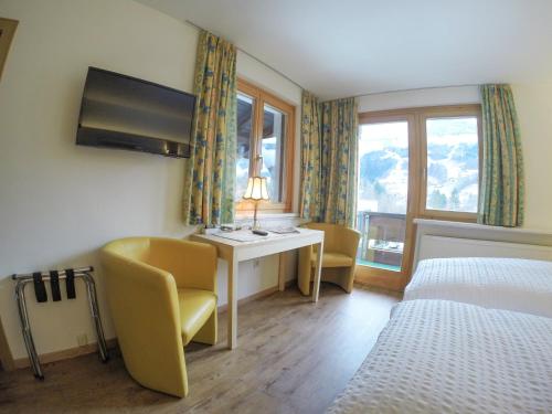 施伦斯Hotel Both的酒店客房设有书桌、床和窗户。