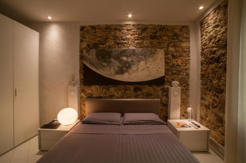巴尔加艺术精品阿琪亚帕苏格尼住宿加早餐旅馆的一间卧室设有一张床和石墙