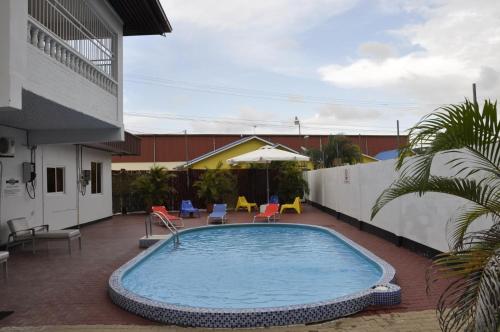 帕拉马里博Riando appartement的一座带椅子的庭院内的游泳池以及一座建筑
