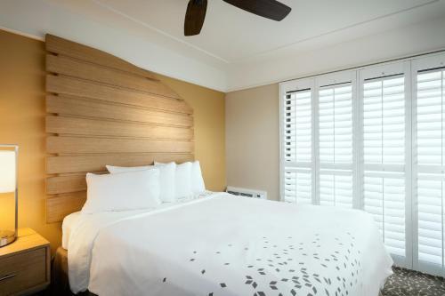 圣地亚哥达艾默德希德酒店的卧室配有一张白色大床和木制床头板