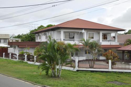帕拉马里博Riando appartement的白色的房子,有红色的屋顶和棕榈树