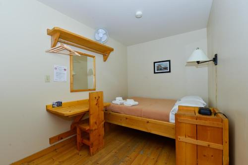 道森市邦克豪斯酒店的一间卧室配有一张带镜子的木床和一张书桌