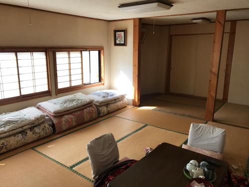 会津若松日观日式旅馆的一间设有两张床和一张桌子的房间