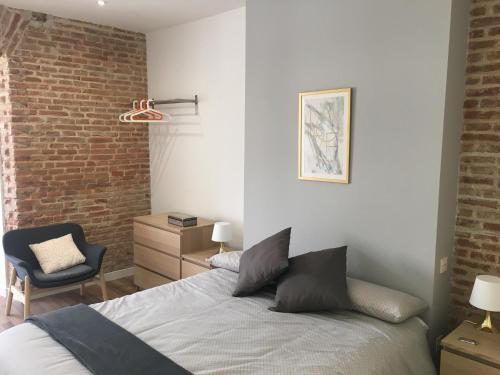 巴利亚多利德AIRVA: Apartamento Teresa Gil的一间卧室设有一张床和砖墙