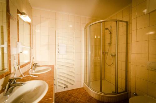 PlanneralmAlpengasthof Grimmingblick的浴室设有玻璃淋浴间和2个水槽。