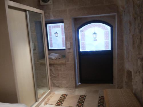 纳布卢斯Khan Alwakala Hotel的浴室设有黑色的门和镜子