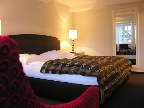 雷达-维登布吕克埃姆多克特尔普拉兹酒店的一间卧室配有一张大床,床上有毯子