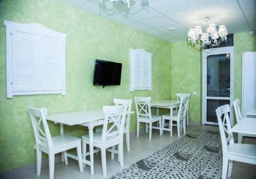 霍斯塔Khosta Garden Hotel的一间配备有白色桌椅和电视的用餐室