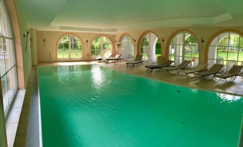 普劳西盖斯德布鲁姆海景酒店的大楼内带椅子的大型游泳池