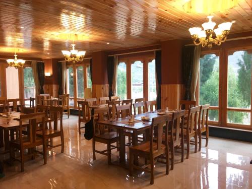 帕罗Hotel Khamsum的用餐室设有木桌、椅子和窗户。