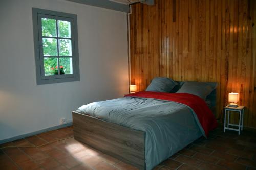 Sainte-Eulalie-en-BornLa Maison Ratabou的一间卧室配有一张木墙床