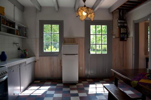 Sainte-Eulalie-en-BornLa Maison Ratabou的厨房配有冰箱、桌子和窗户。
