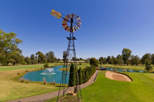 Howlong豪龙高尔夫度假村的一座带池塘的高尔夫球场上的风车