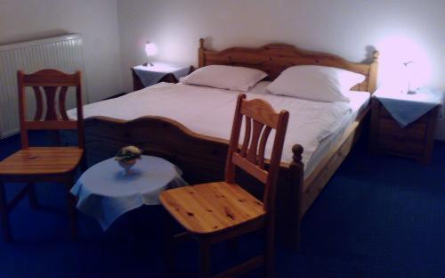 巴特伊堡皇家花园酒店的一间卧室配有一张带两把椅子和一张桌子的床。