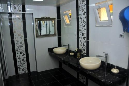 安塔利亚纳萨弗洛拉酒店的浴室设有黑色柜台上的两个盥洗盆