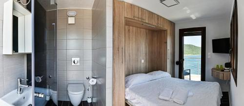 阿莫利亚尼岛Pension Limani的配有一张床的浴室和带淋浴的浴室