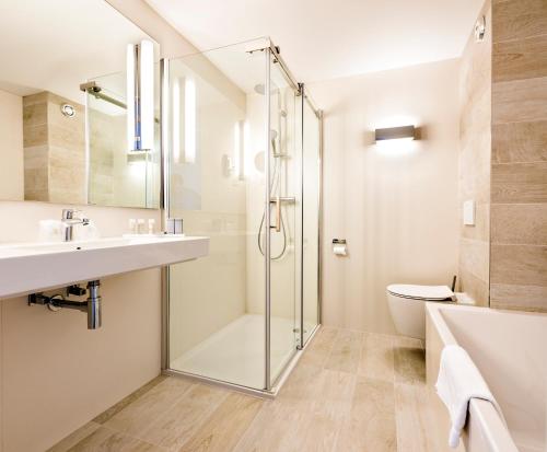 西泰尔斯海灵WestCord Hotel Schylge的带淋浴、盥洗盆和卫生间的浴室