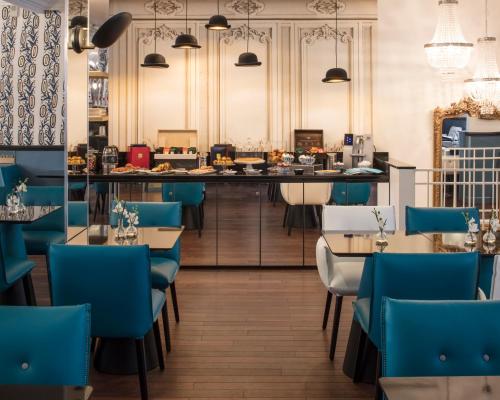 巴黎马尔特阿斯托特尔酒店的一间设有蓝色椅子的餐厅和一间酒吧