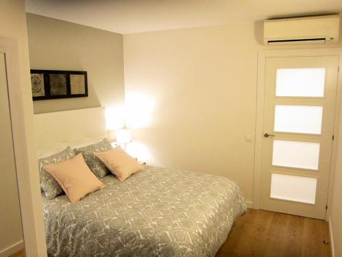 滨海托萨Tossa Unique Moments Apartment的一间卧室配有一张带两个枕头的床