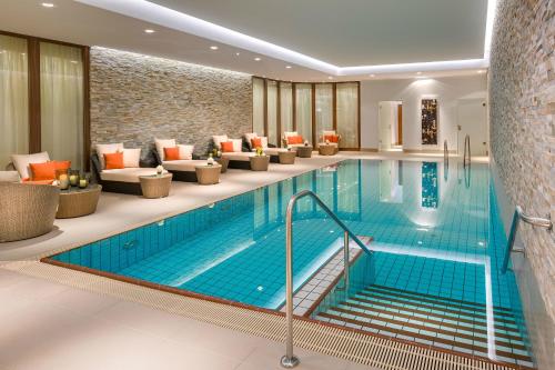 杜塞尔多夫Breidenbacher Hof, Best Grandhotel 2024 - Die 101 Besten的酒店大堂的游泳池,设有长沙发和等候室