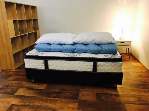 StöðvarfjörðurÓseyri Hlaðan -The Barn studio apartment的床上铺有蓝色和白色枕头的床