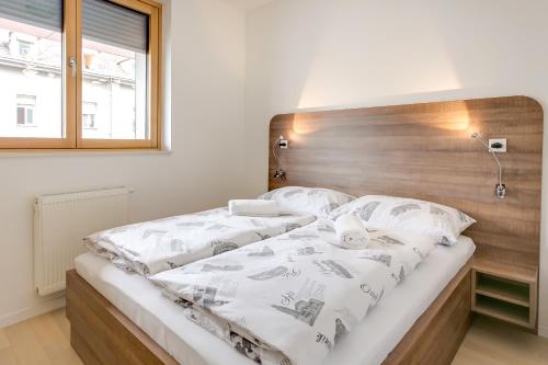 萨格勒布Apartment Nova Cesta 62的一间卧室配有一张大床和木制床头板
