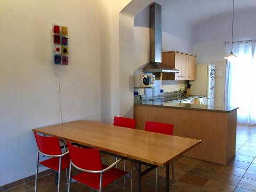 卡斯特罗·德波利亚斯Apartament Can Callis的厨房配有木桌和红色椅子