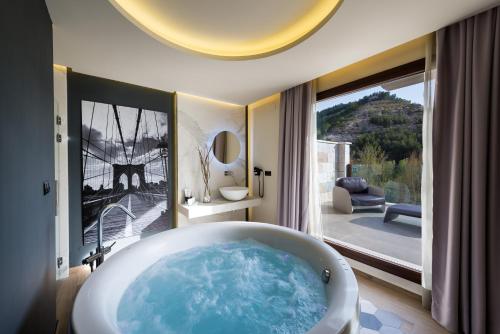 阿尔卡拉德尔胡卡尔艾丽娅Spa酒店的带浴缸的浴室和大窗户