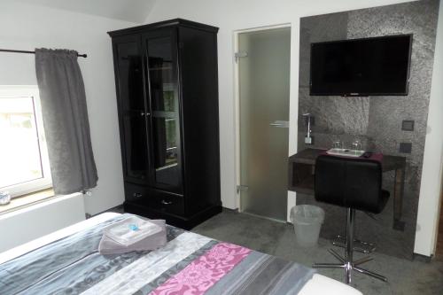 杜塞尔多夫格里旅馆的一间卧室配有一张床、梳妆台和电视。