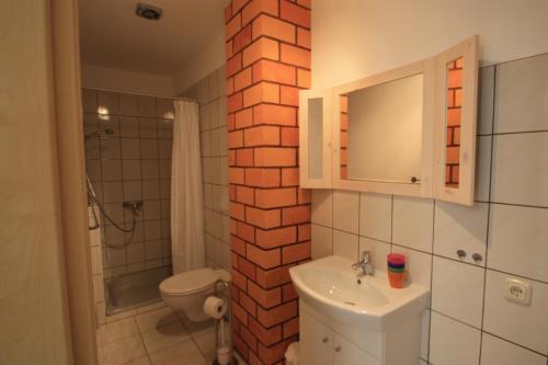 Hirschburg沃尔姆达尔斯半岛旅馆的一间带白色水槽和砖墙的浴室