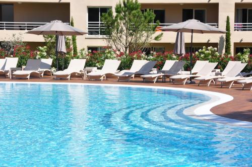维琪奥港萨利纳湾公寓酒店的一个带躺椅和遮阳伞的游泳池