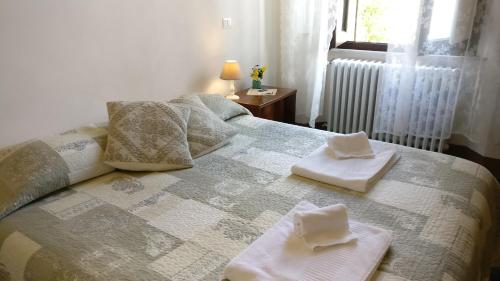 锡耶纳锡耶纳拉契卡住宿加早餐旅馆的一间卧室配有带毛巾的床