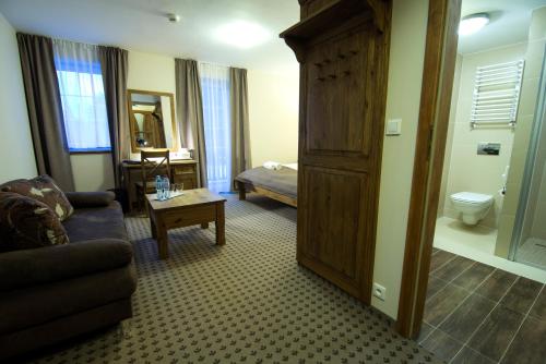 斯克拉斯卡波伦巴冬季两项运动及Spa酒店的客厅配有沙发和一张位于房间的床