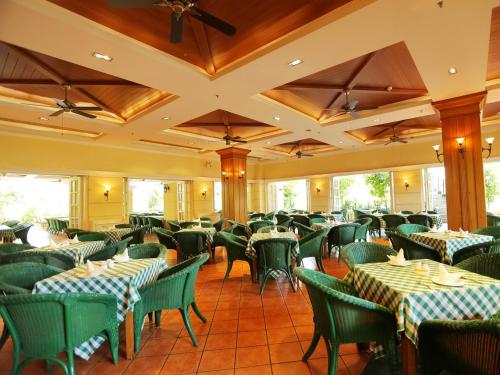 三亚三亚椰林滩大酒店 的用餐室配有绿色的桌椅
