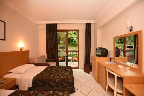 厄吕代尼兹裴迪绮亚海滩酒店的酒店客房配有一张床、一张书桌和一台电视。